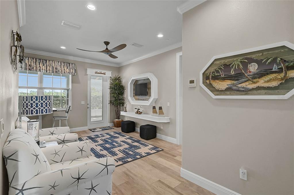 A living room features a starfish-patterned chair, a blue patterned rug, and coastal wall art — 205 E VENICE AVENUE, VENICE, FL