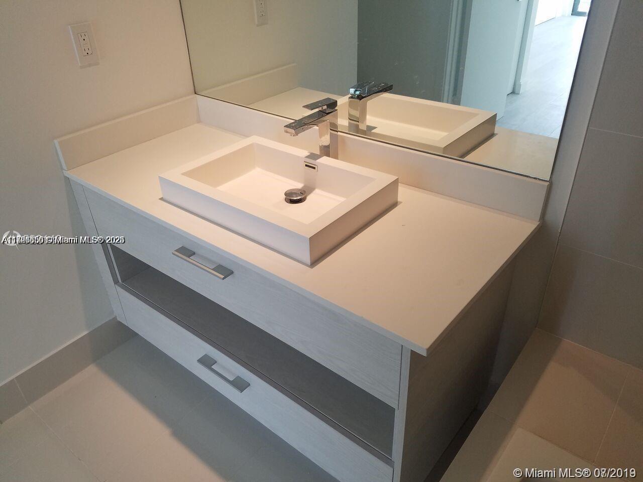 A modern bathroom vanity features a white countertop, a rectangular vessel sink, and chrome fixtures — 55 SW 9th St # 1805, Miami FL 33130, MIAMI, FL