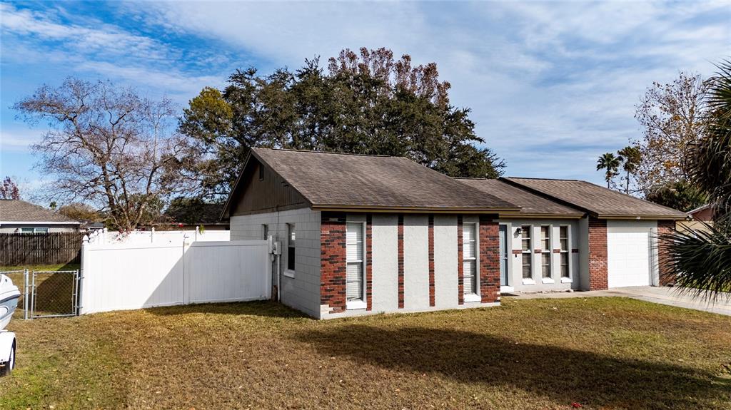 An empty room with wood-look flooring, white walls, and a vaulted ceiling with exposed beams — 115 TOLUCA DRIVE, KISSIMMEE, FL