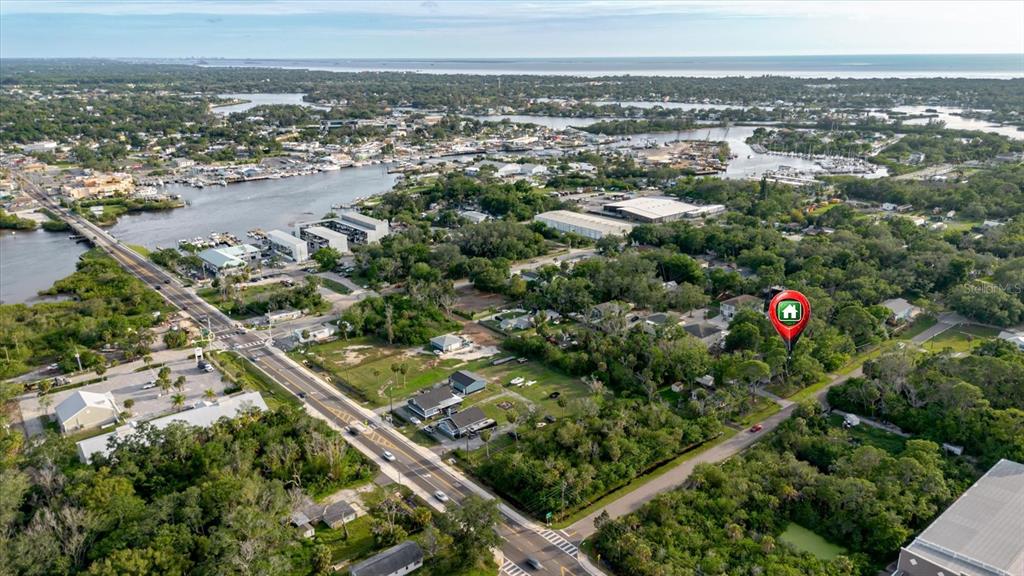 An aerial view shows a coastal neighborhood with a house marked by a location pin — HIGHLAND AVENUE, TARPON SPRINGS, FL