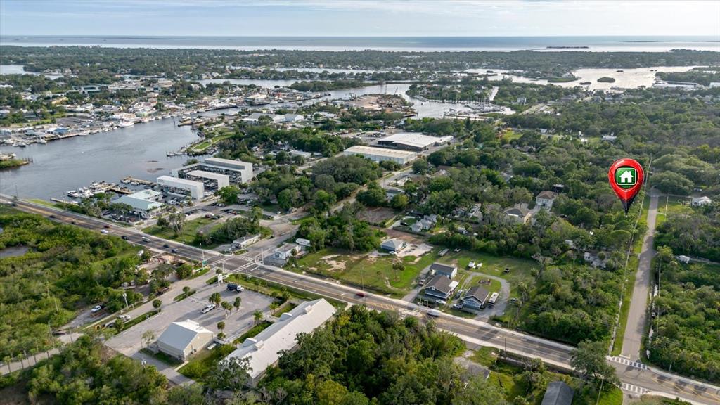 This aerial view shows a coastal area with a house marked by a location pin — HIGHLAND AVENUE, TARPON SPRINGS, FL