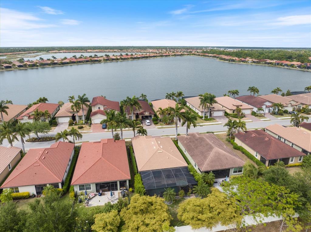 An aerial view shows a row of suburban houses with screened lanais facing a lake — 191 MARAVIYA BOULEVARD, NORTH VENICE, FL