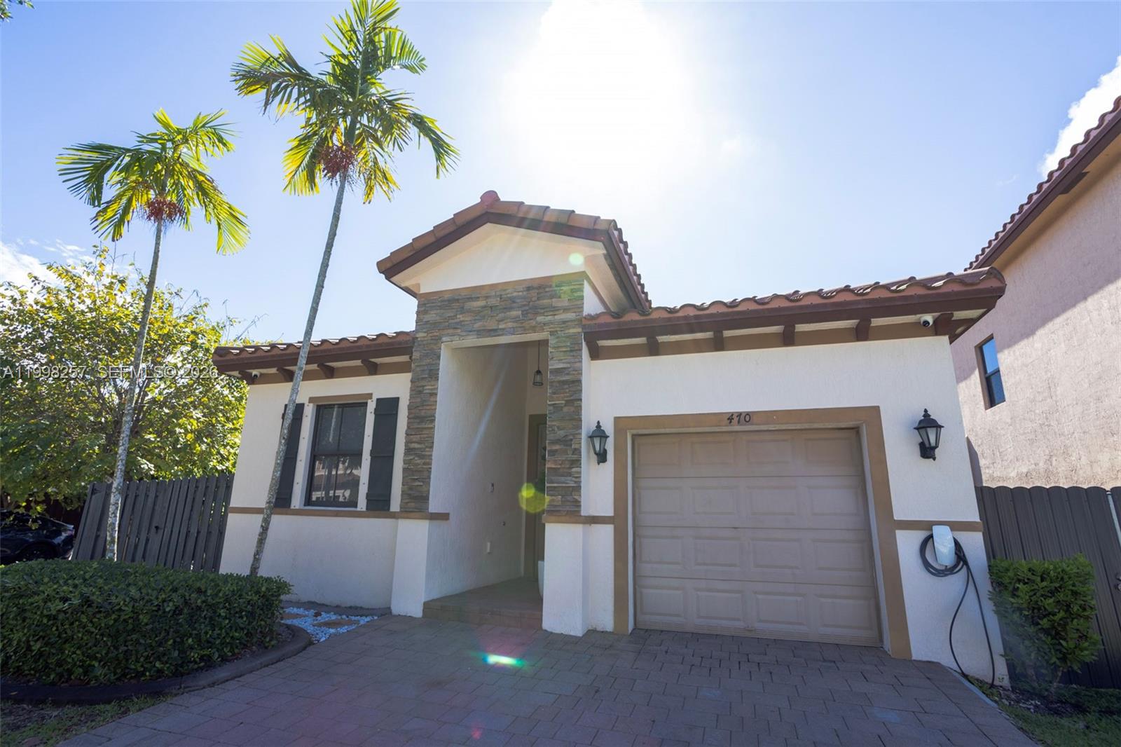 A single-story house with a stone-accented entryway, a one-car garage, and a palm tree — 470 SE 34TH TER, Homestead FL 33033, HOMESTEAD, FL