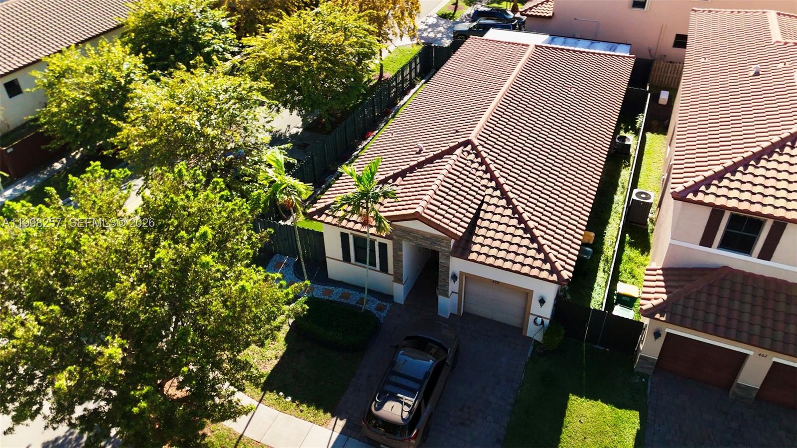 An aerial view shows a single-story house with a tiled roof and a paved driveway — 470 SE 34TH TER, Homestead FL 33033, HOMESTEAD, FL