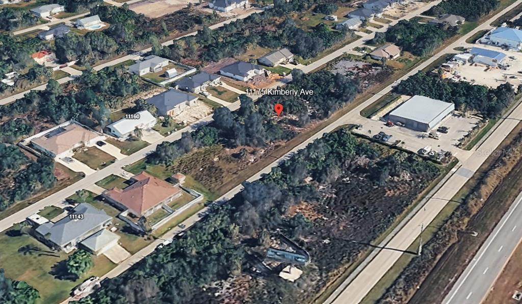 An aerial view shows a vacant, wooded residential lot surrounded by houses and a road — 11175 KIMBERLY AVENUE, ENGLEWOOD, FL