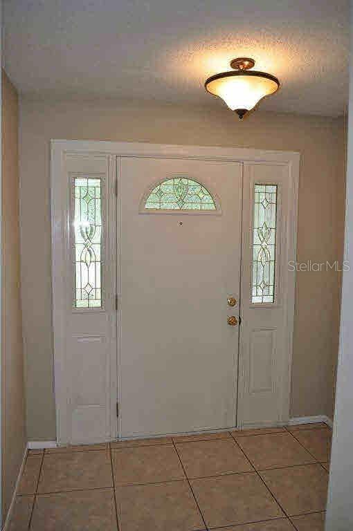 An entryway features a white front door with sidelights, a semi-flush mount light, and tile flooring — 860 MAPLE FOREST DRIVE, ORLANDO, FL