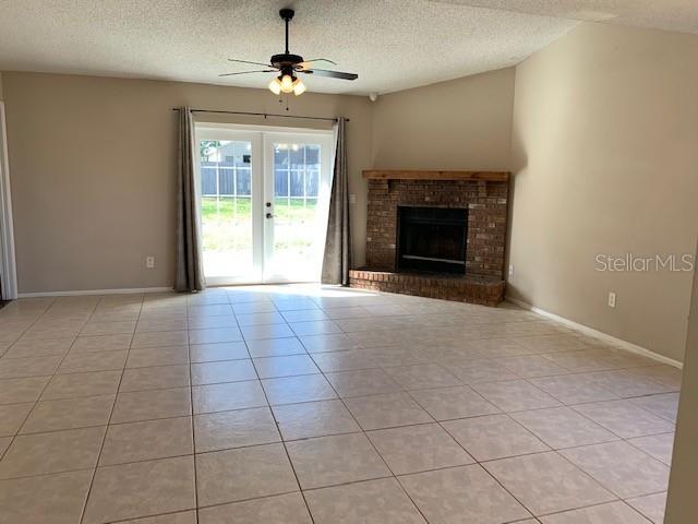A living room features light tile flooring, a brick fireplace, and glass doors to the backyard — 860 MAPLE FOREST DRIVE, ORLANDO, FL