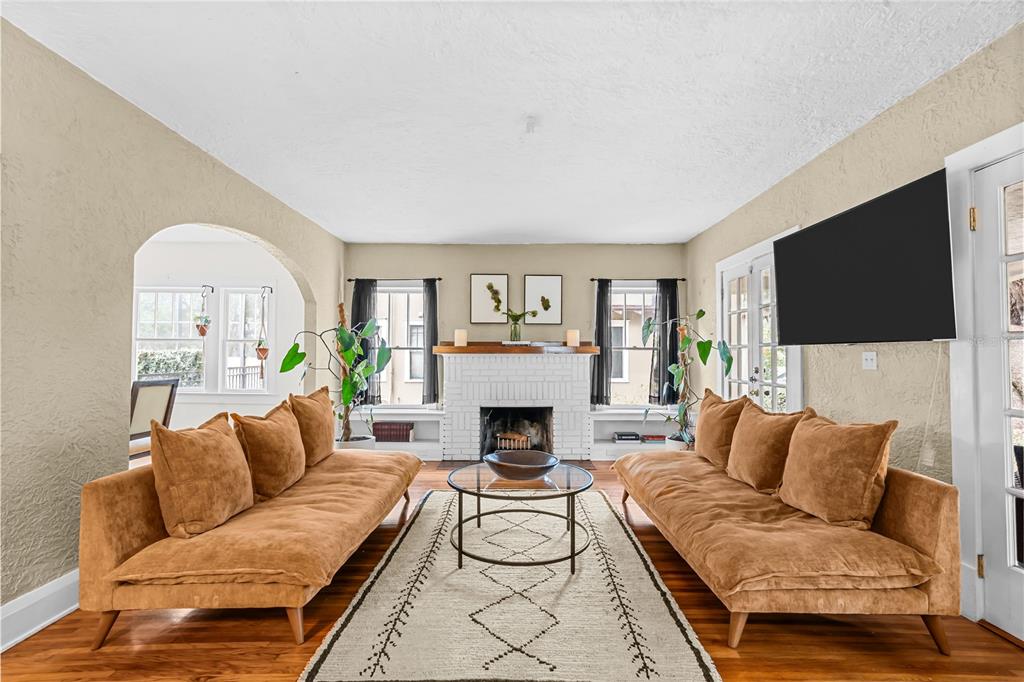 A living room features two tan sofas, a white brick fireplace, and a patterned rug — 210 PHILLIPS PLACE, ORLANDO, FL