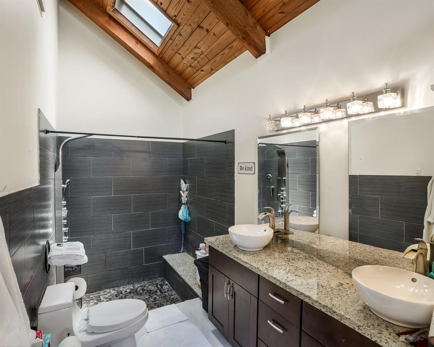 A bathroom features a double vanity, a walk-in shower with dark tiles, and a skylight — 407 N University Drive, Plantation FL 33324, PLANTATION, FL