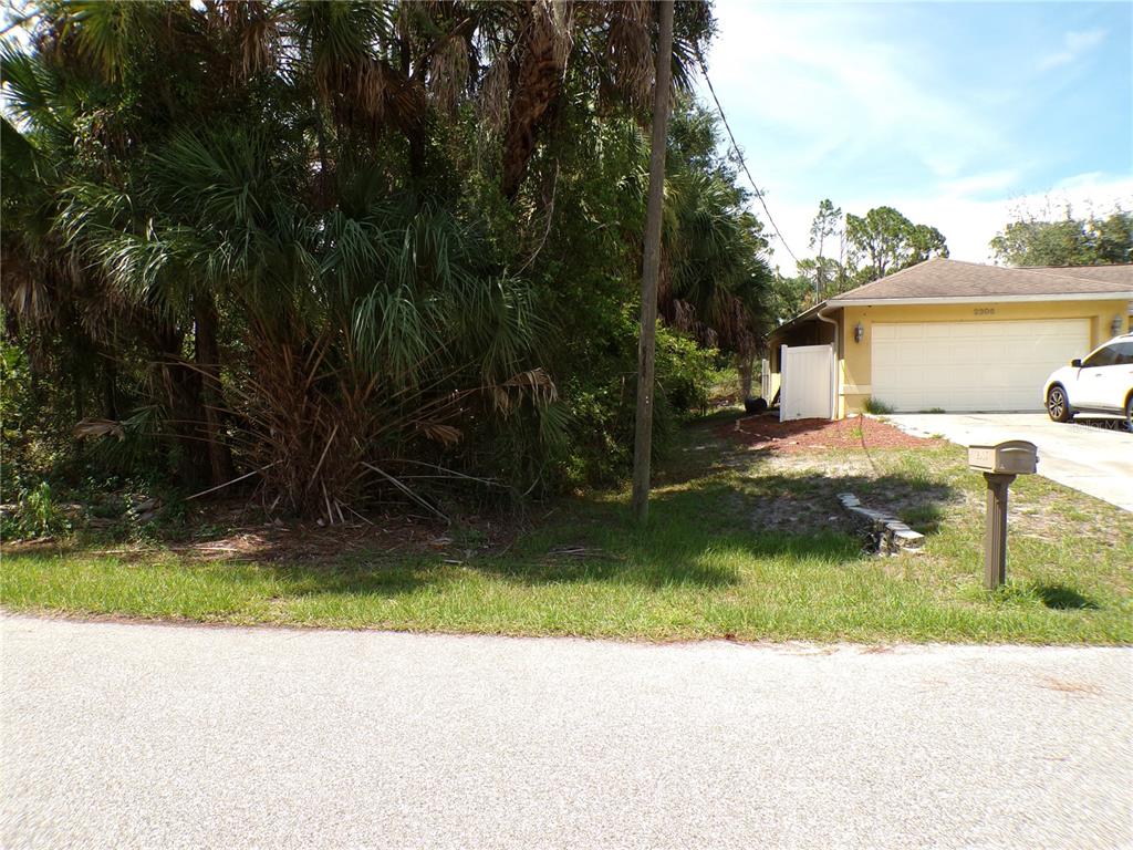 A vacant, wooded lot sits next to a house with a two-car garage — ARMENIA ROAD, NORTH PORT, FL