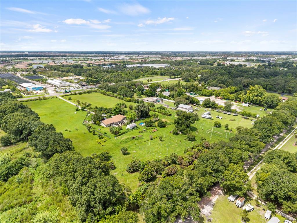 An aerial view shows a rural property with a house, outbuildings, and scattered trees — 16305 E STATE ROAD 64, BRADENTON, FL