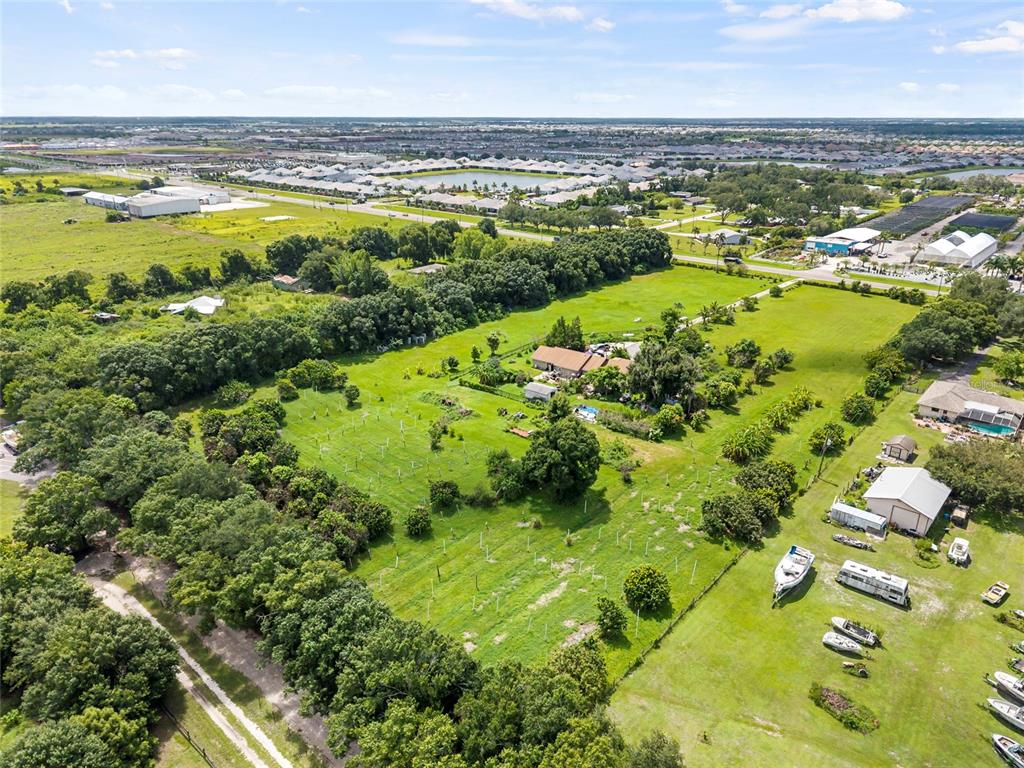 An aerial view shows a rural property with a house, outbuildings, and scattered trees — 16305 E STATE ROAD 64, BRADENTON, FL