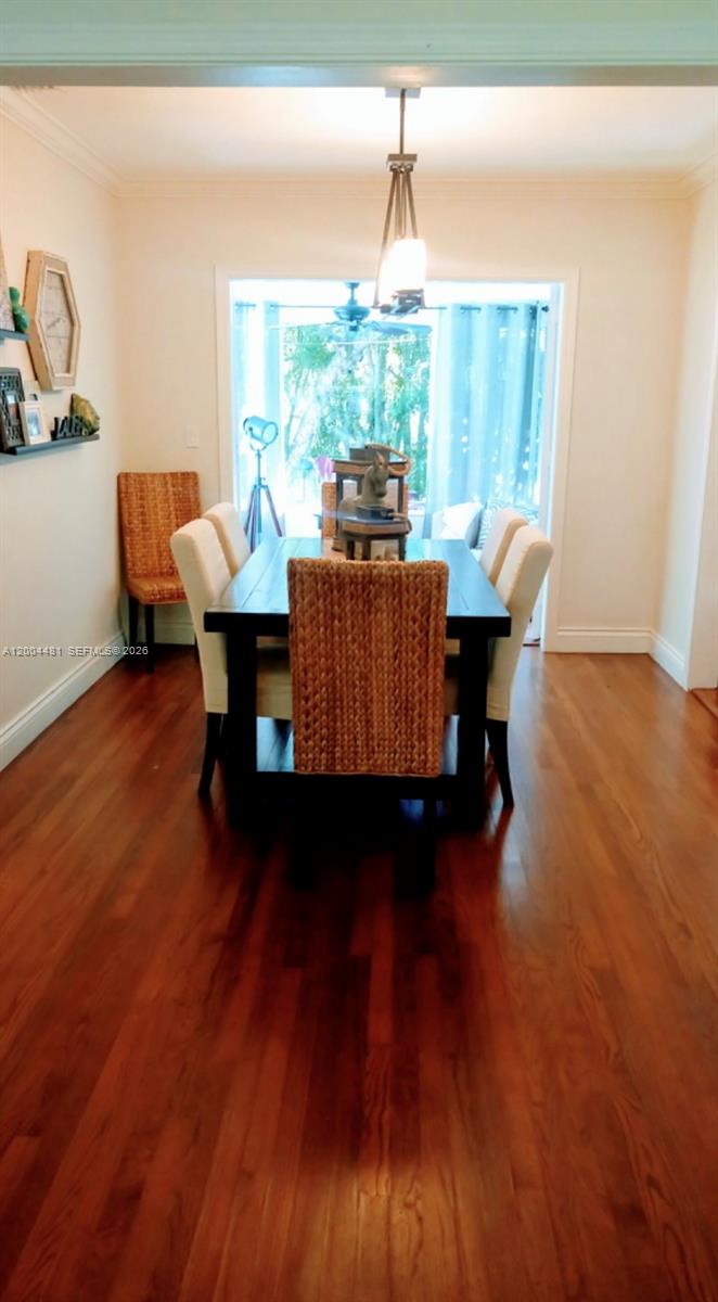 A dining room features a dark wood table, woven chairs, and hardwood flooring — 5718 SW 48th St, South Miami FL 33155, SOUTH MIAMI, FL