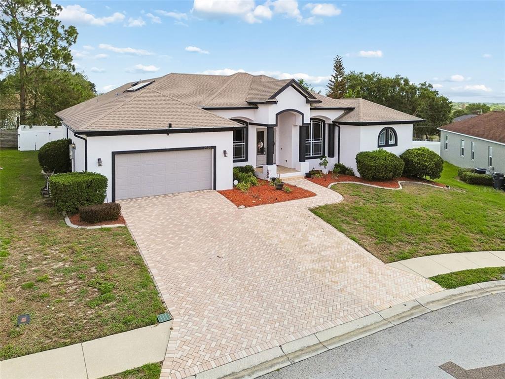 A single-story house with a white stucco exterior, dark trim, and a paved driveway — 2325 CHESTERFIELD CIRCLE, LAKELAND, FL