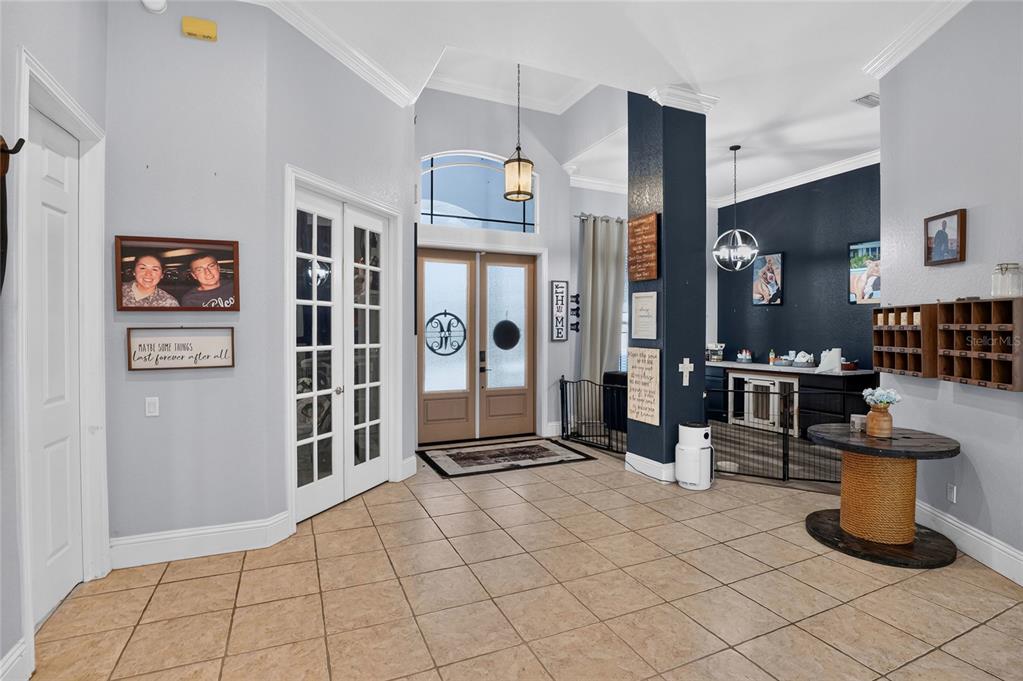 A spacious entryway features light-colored tile flooring, double front doors, and a dark accent wall — 2325 CHESTERFIELD CIRCLE, LAKELAND, FL