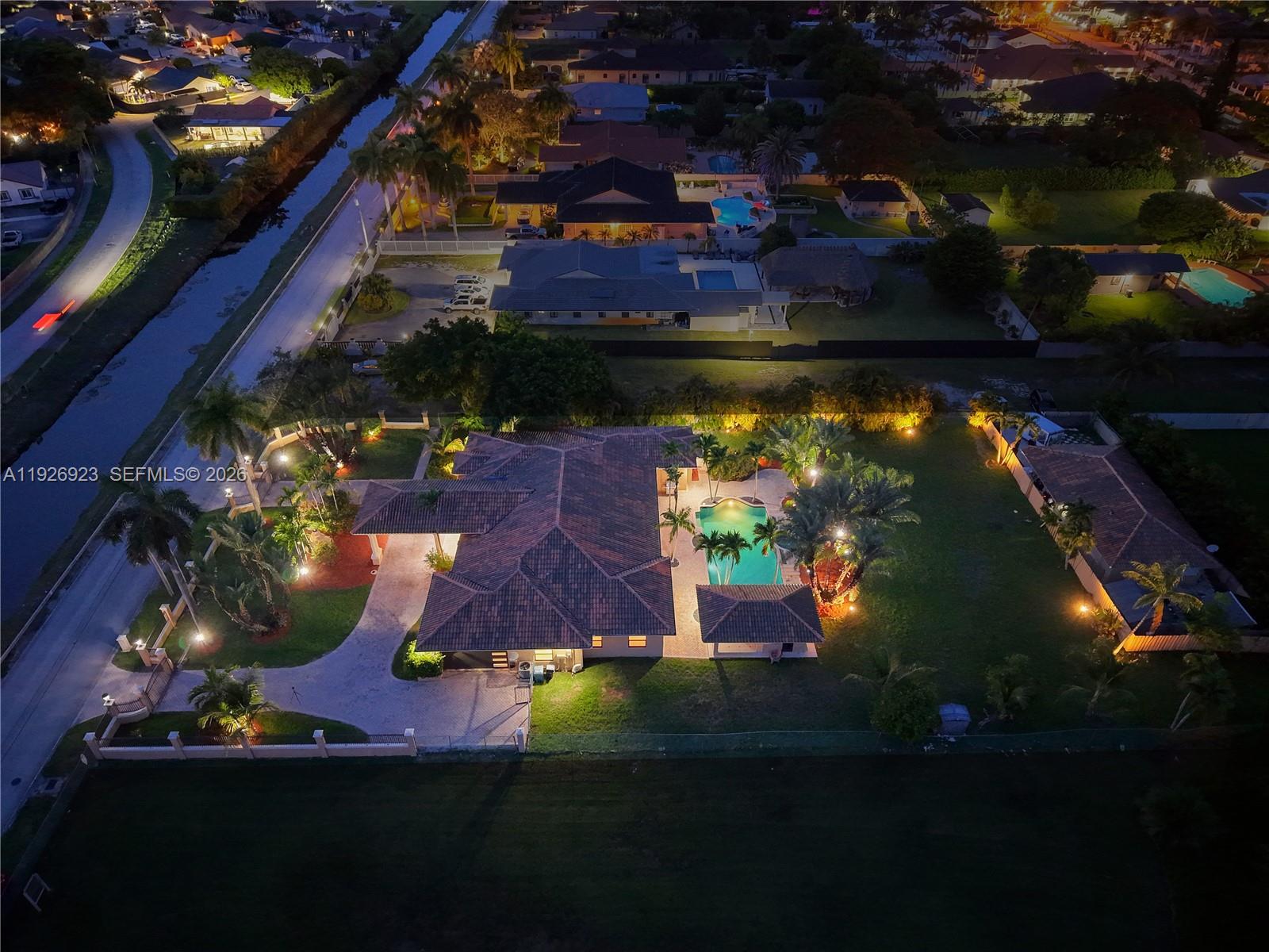 An aerial night view shows a house with a pool, patio, and landscaped yard — 3001 SW 132nd Ave, Miami FL 33175, MIAMI, FL
