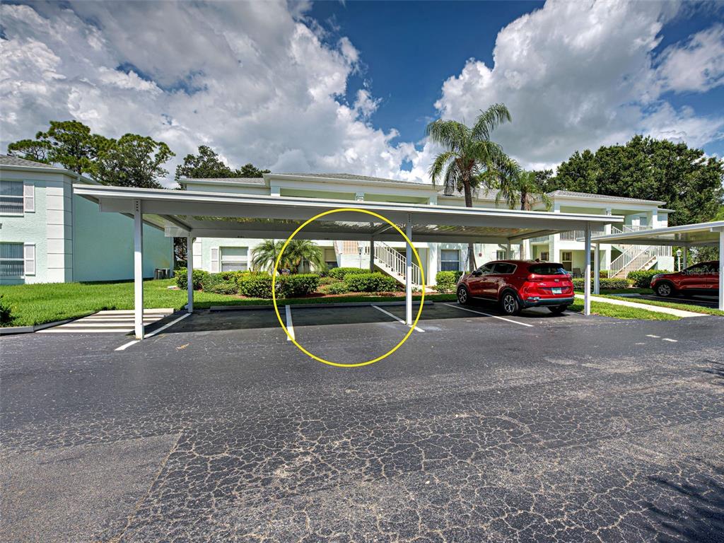 A covered parking area with marked spaces sits in front of a multi-story apartment building — 5725 GREENWOOD AVENUE UNIT 9201, NORTH PORT, FL