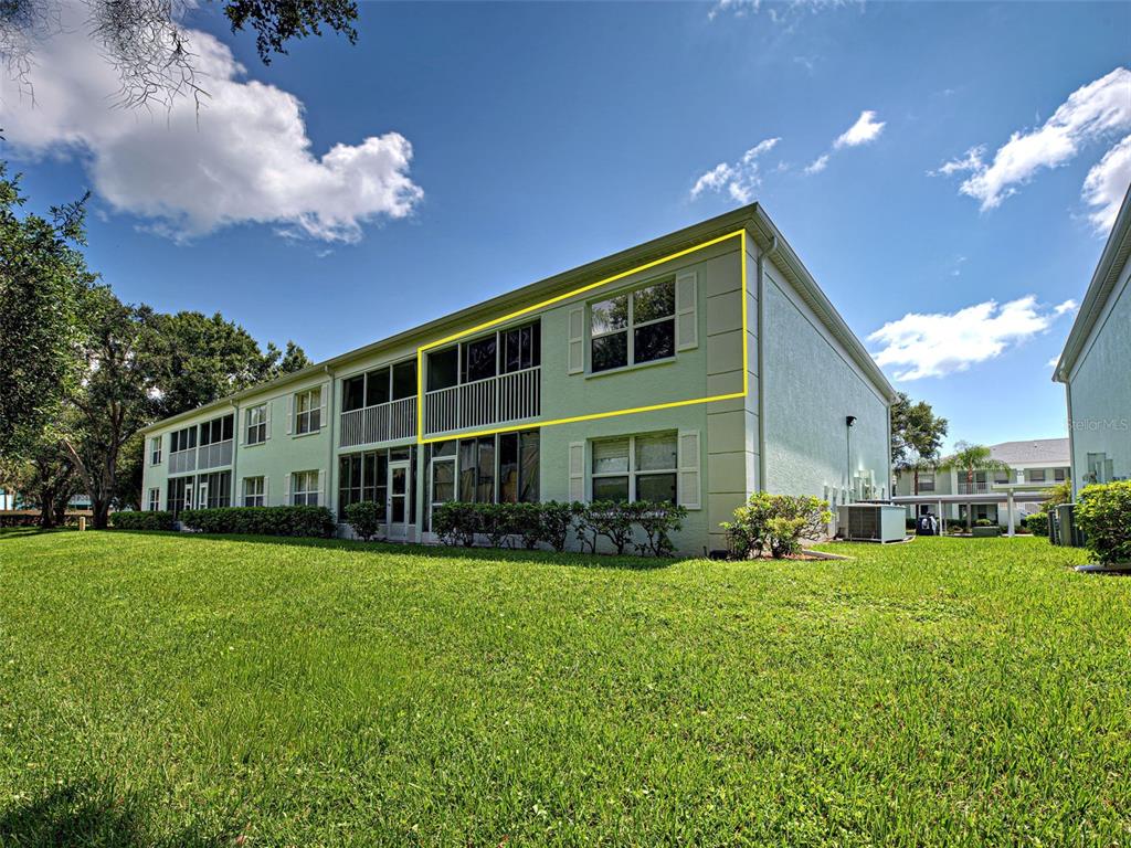 The exterior of a two-story apartment building features a screened balcony and white shutters — 5725 GREENWOOD AVENUE UNIT 9201, NORTH PORT, FL