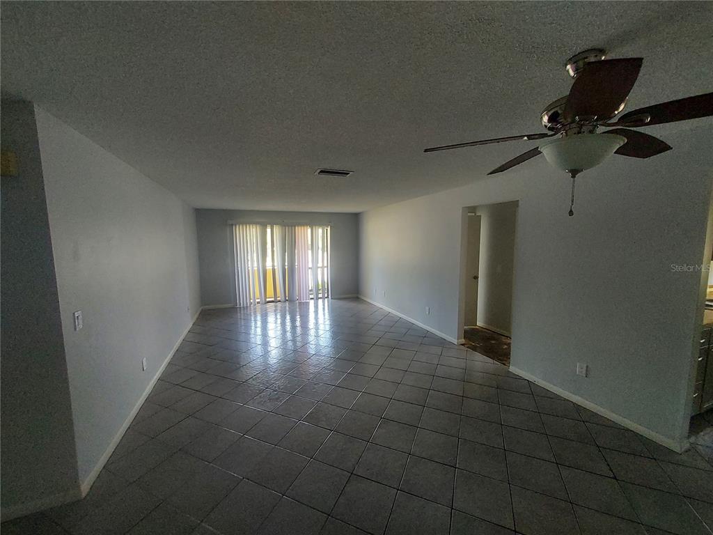 A spacious living area features light gray walls, diagonal floor tiles, and a ceiling fan — 3535 E FORT KING STREET UNIT 160, OCALA, FL