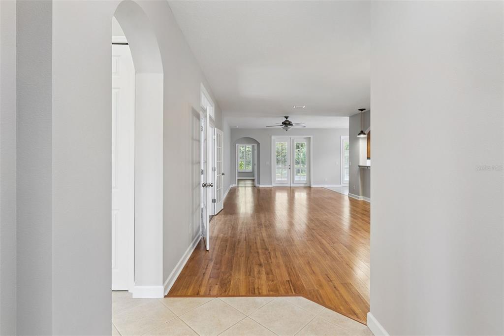A view from a tiled entryway looking into a living area with hardwood floors — 8270 BRIDGEPORT BAY CIRCLE, MOUNT DORA, FL