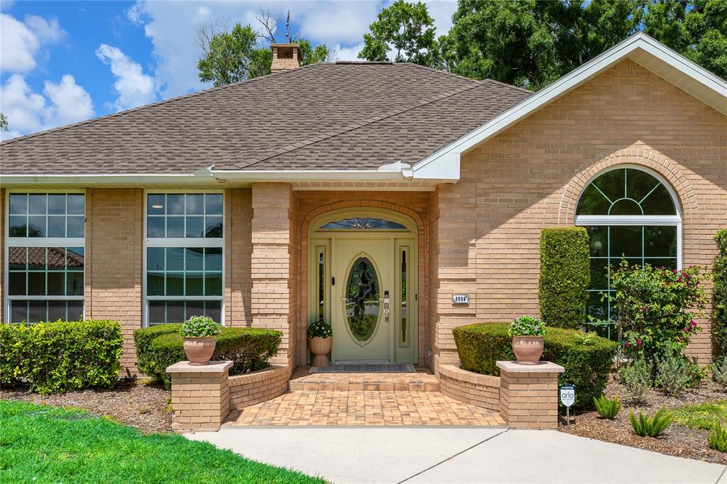 A single-story brick house features a light green front door and a paved entryway — 4908 TAYWATER DELL, SARASOTA, FL