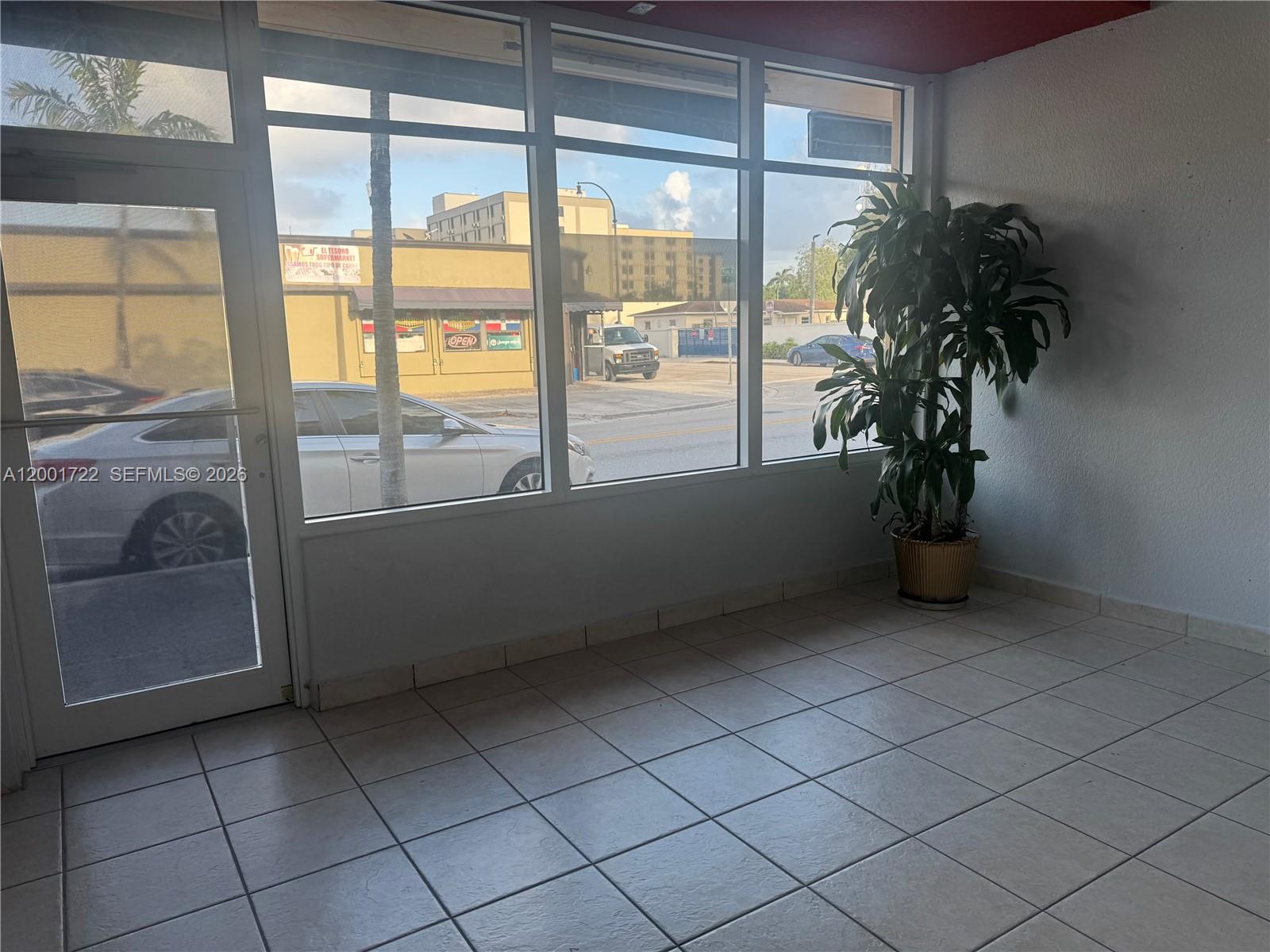 An interior room with tiled floors, large windows, and a potted plant by the wall — 700 Palm Ave # 702, Hialeah FL 33010, HIALEAH, FL