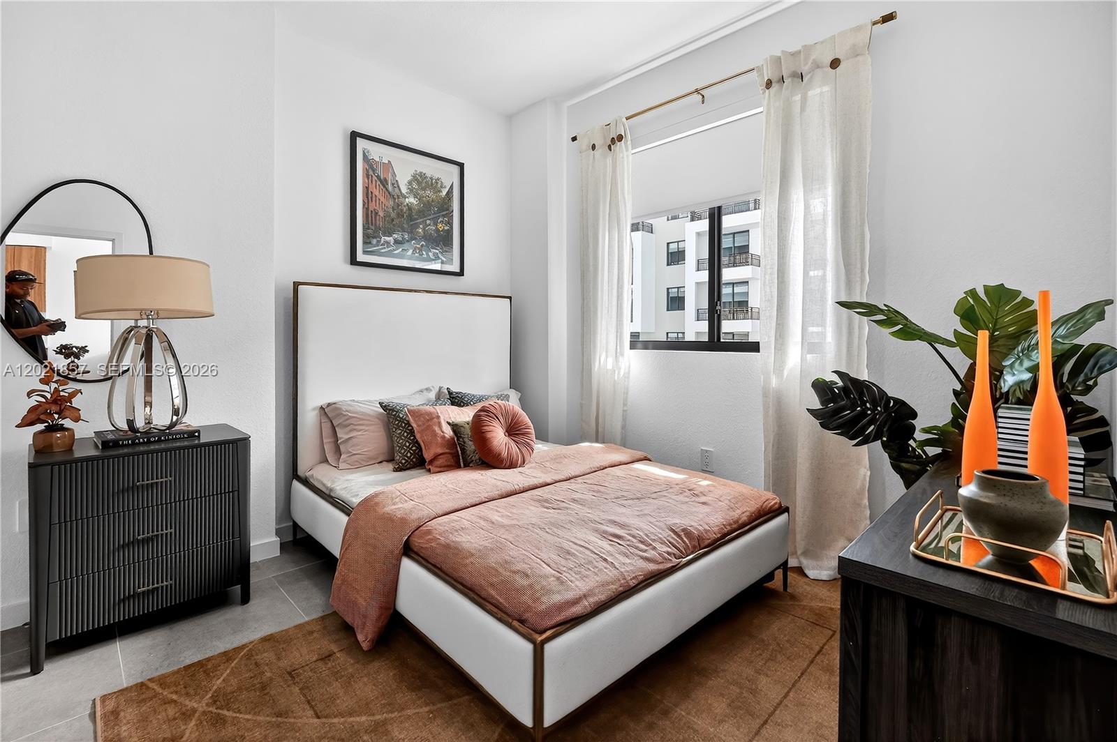 A bedroom features a bed with a white headboard, a black dresser, and a window — 2001 Van Buren St # 502, Hollywood FL 33020, HOLLYWOOD, FL