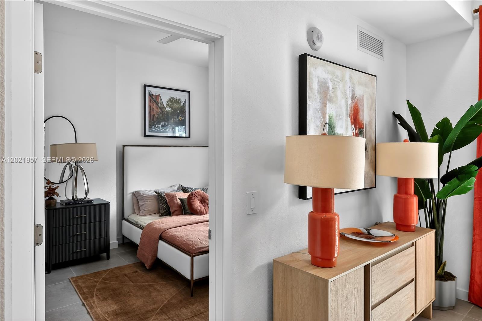 A bedroom is visible through a doorway next to a wooden console with orange lamps — 2001 Van Buren St # 502, Hollywood FL 33020, HOLLYWOOD, FL