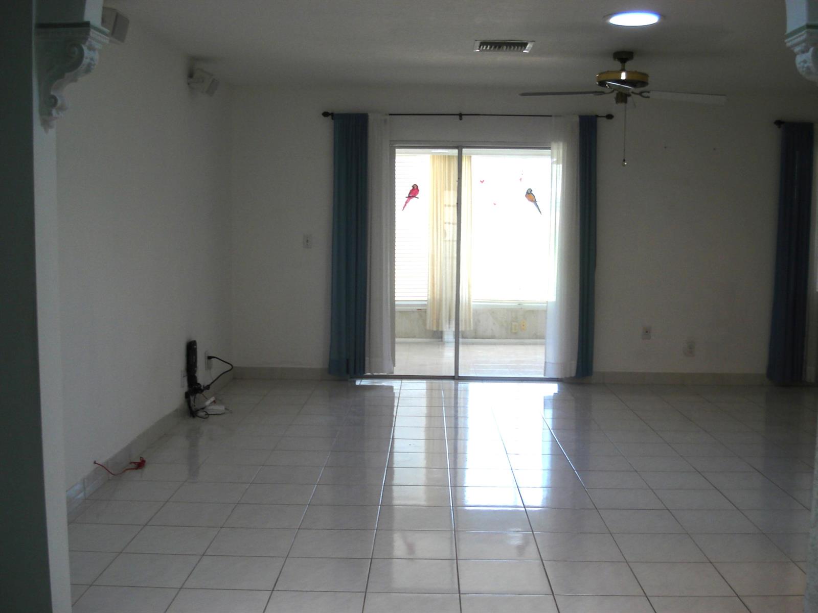 An empty room with white walls, tiled floors, a ceiling fan, and sliding glass doors — 13368 Via Vesta # B, Delray Beach FL 33484, DELRAY BEACH, FL