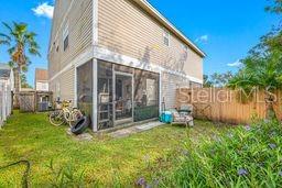 The exterior of a two-story house features a screened-in patio and a fenced backyard — 132 DOUGLAS ROAD W UNIT A, OLDSMAR, FL