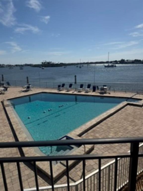 A swimming pool overlooks a bay with boats under a clear blue sky — 101 N RIVERSIDE DRIVE UNIT 2020, NEW SMYRNA BEACH, FL