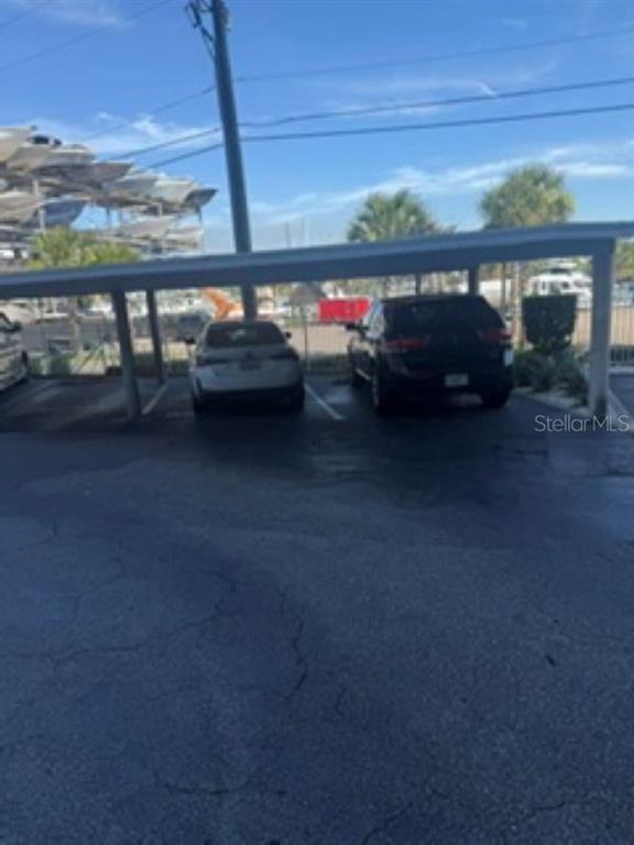 A covered parking area with two cars parked under a structure on a sunny day — 101 N RIVERSIDE DRIVE UNIT 2020, NEW SMYRNA BEACH, FL