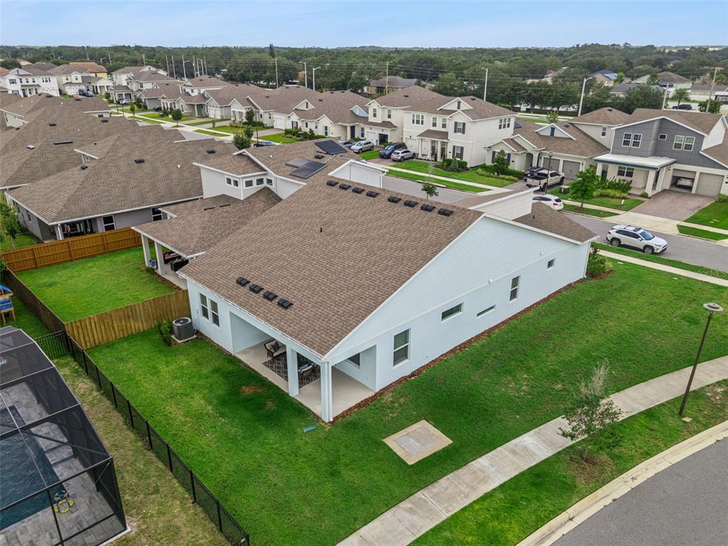 An aerial view shows a suburban house with a brown shingled roof and backyard patio — 19307 BANFIELD PLACE, ORLANDO, FL