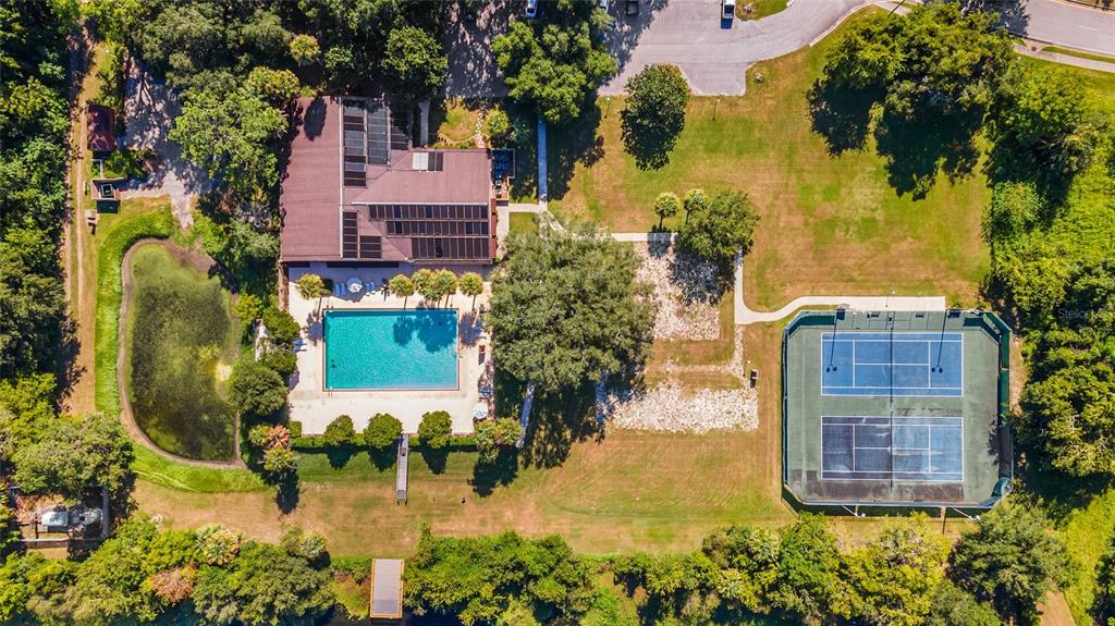 An aerial view shows a house with solar panels, a swimming pool, and a tennis court — 2656 SW 20TH CIRCLE, OCALA, FL