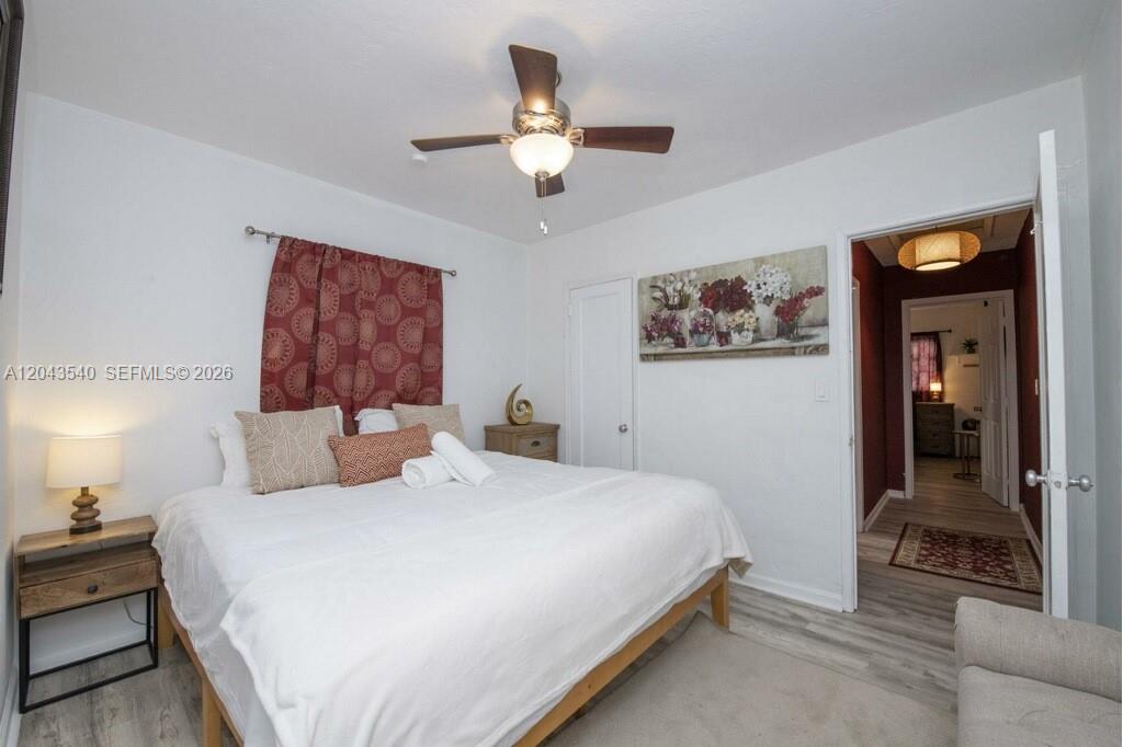 A bedroom features a bed with white bedding, a ceiling fan, and a doorway leading elsewhere — 2721 SW 30th Ave, Miami FL 33133, MIAMI, FL