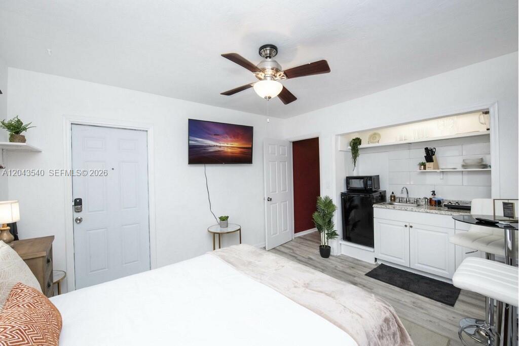 This studio apartment features a bed, a small kitchenette, and a wall-mounted television — 2721 SW 30th Ave, Miami FL 33133, MIAMI, FL