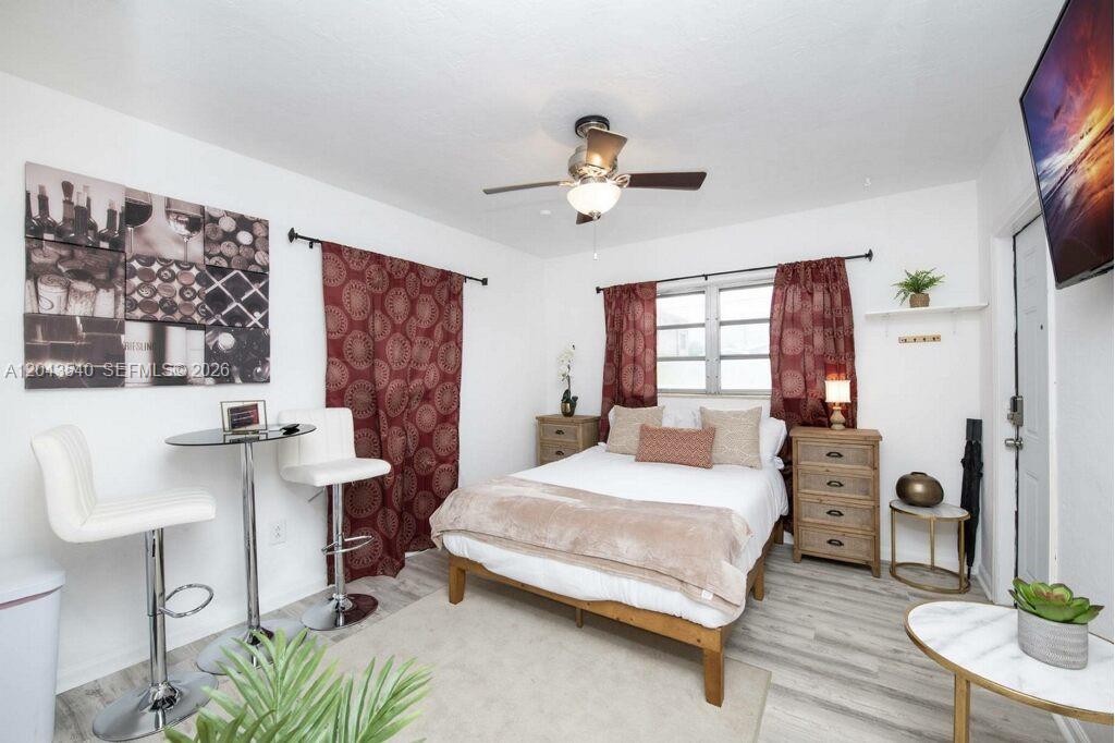A bedroom features a bed, a small dining table with two chairs, and patterned curtains — 2721 SW 30th Ave, Miami FL 33133, MIAMI, FL