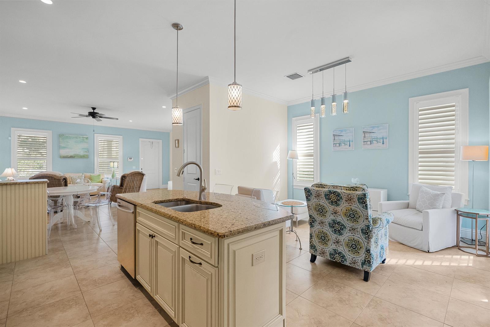 A kitchen island with granite countertops sits in an open-concept room with light blue walls — 10187 S Ocean Drive # 1, Jensen Beach FL 34957, JENSEN BEACH, FL