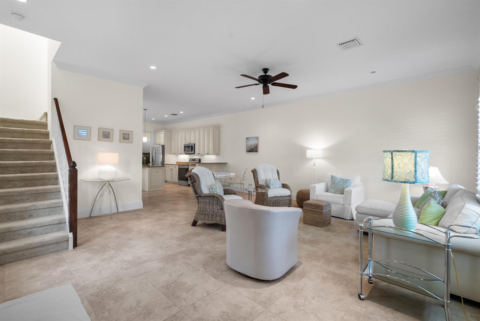 An open-concept living room with tile floors, a staircase, and an adjacent kitchen — 10187 S Ocean Drive # 1, Jensen Beach FL 34957, JENSEN BEACH, FL