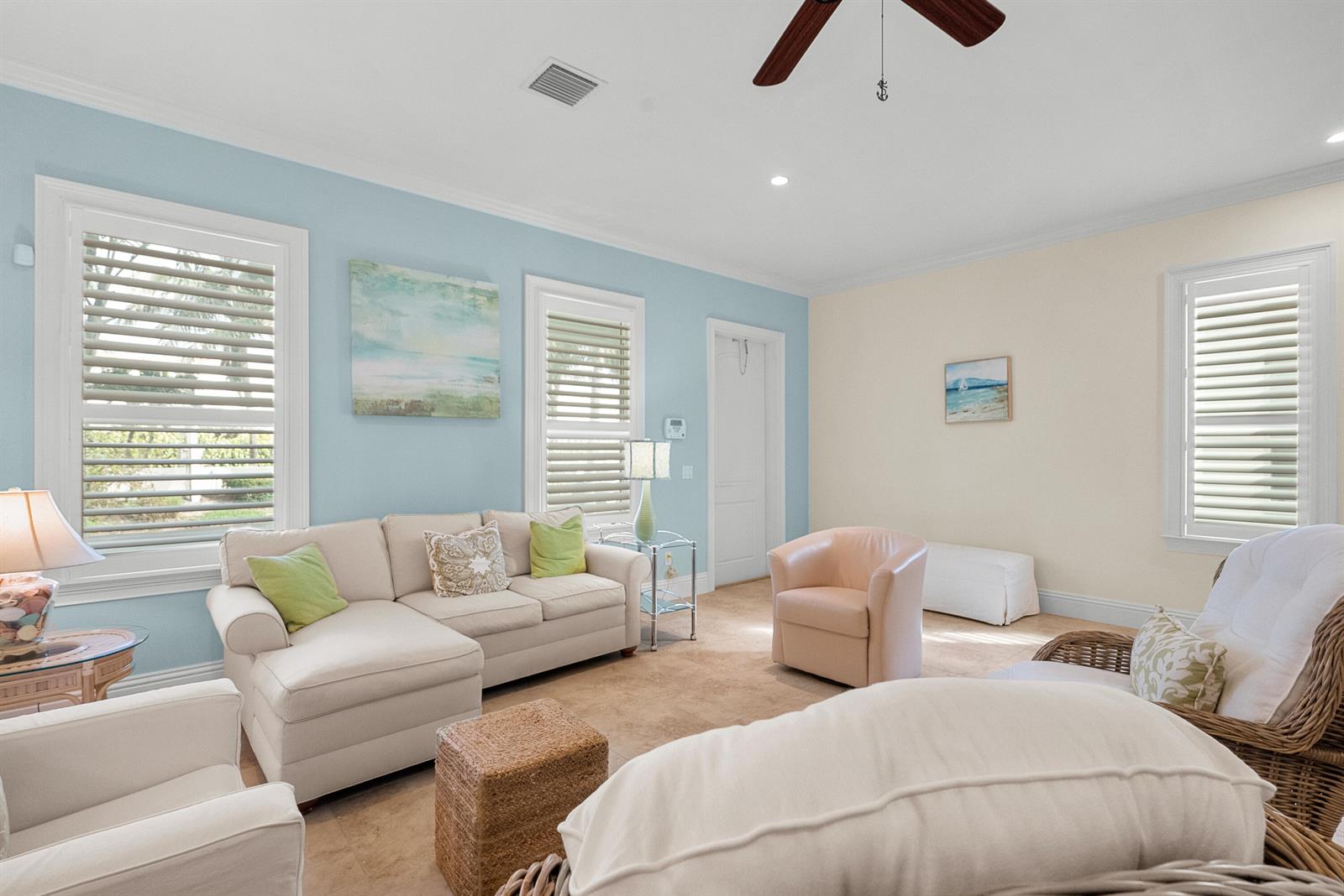 A living room features light blue and cream walls, a sectional sofa, and wicker chairs — 10187 S Ocean Drive # 1, Jensen Beach FL 34957, JENSEN BEACH, FL