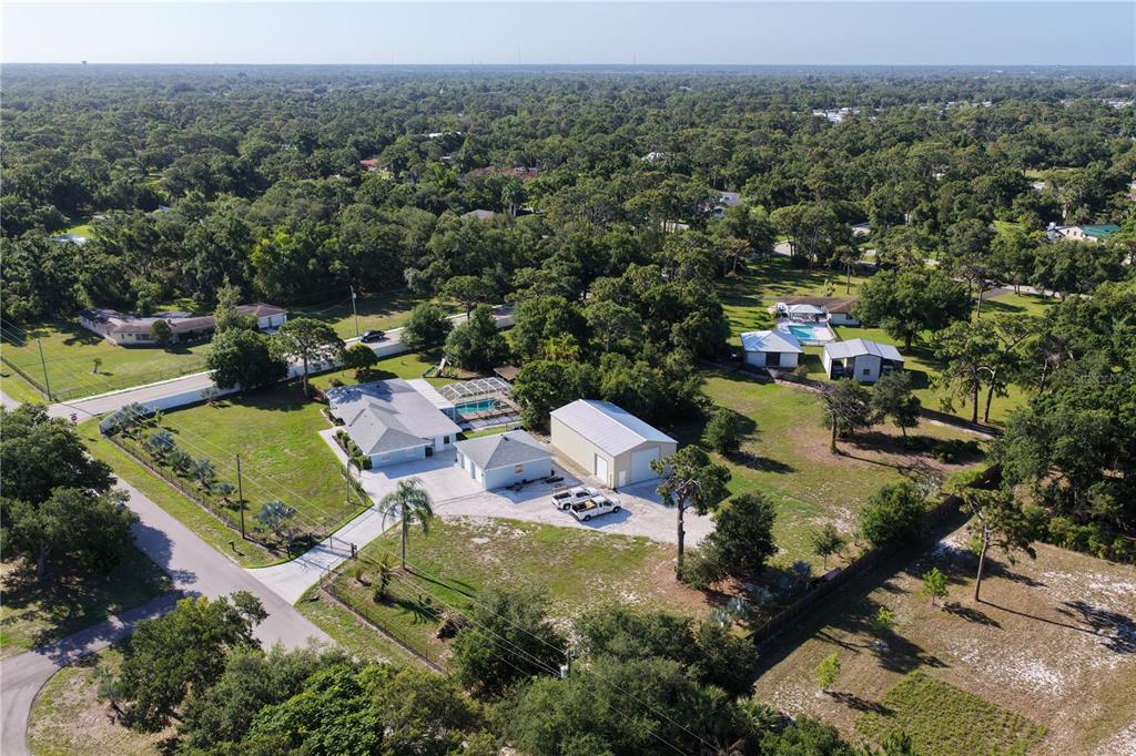 An aerial view shows a residential property with a house, pool, and large detached garage — 2746 53RD STREET, SARASOTA, FL