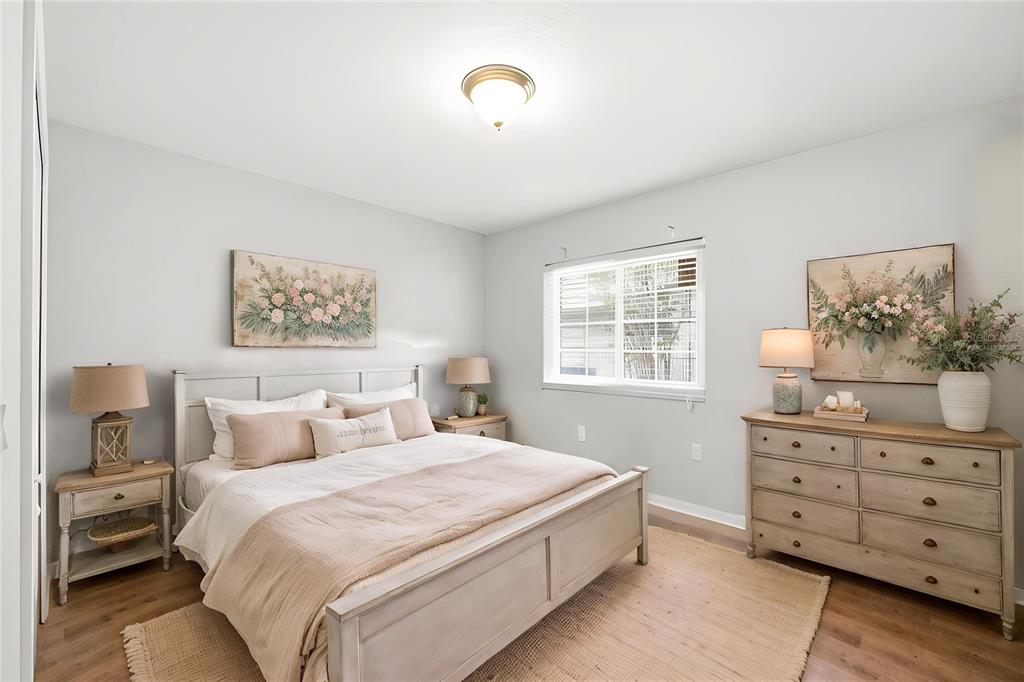 A bedroom features a light-colored bed, a wooden dresser, two nightstands, and a window — 10154 SPRING HILL DRIVE, SPRING HILL, FL