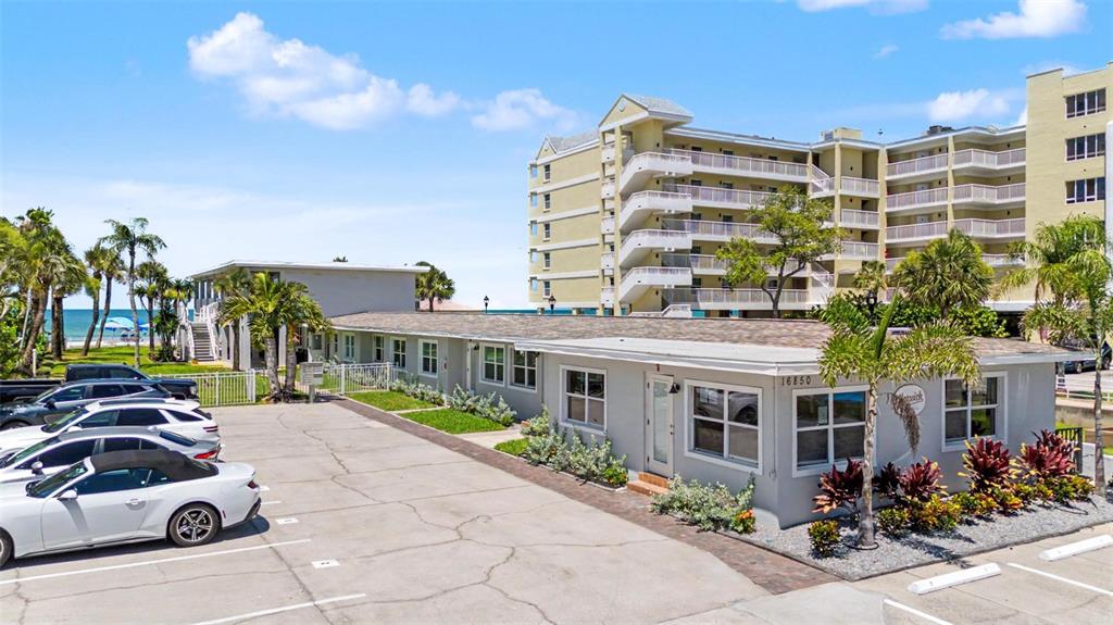 A low-rise building with a parking lot sits in front of a taller apartment complex — 16850 GULF BOULEVARD UNIT 4, NORTH REDINGTON BEACH, FL