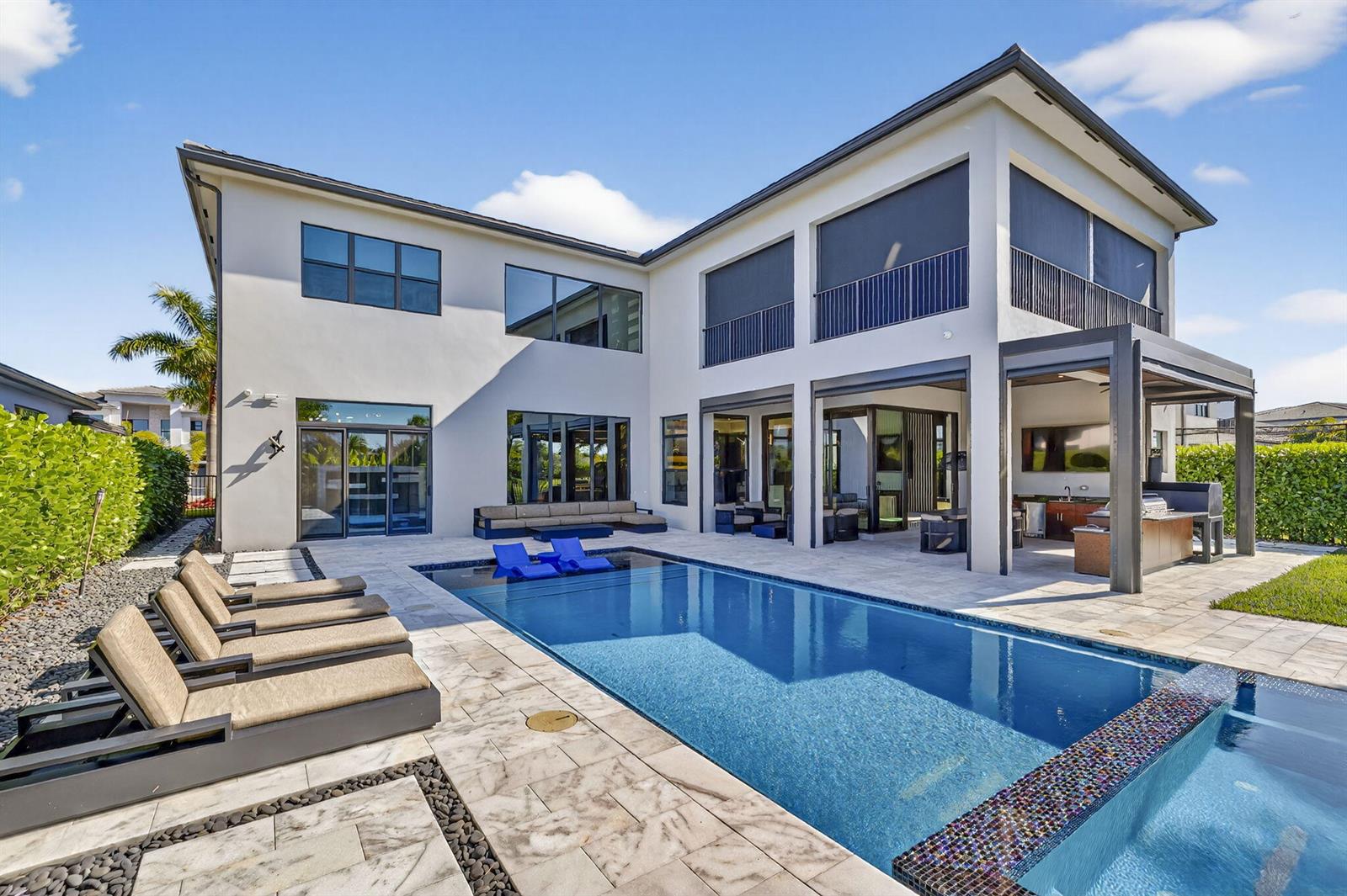 A two-story house exterior features a swimming pool, lounge chairs, and a covered patio area — 9739 Chianti Classico Terrace, Boca Raton FL 33496, BOCA RATON, FL