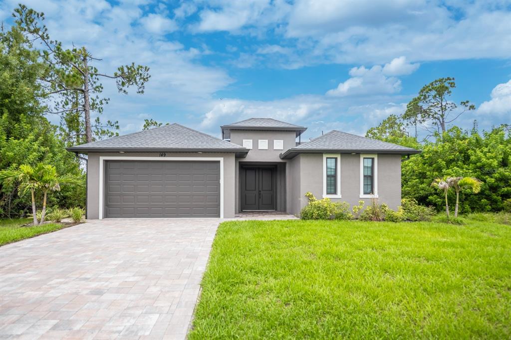 A single-story gray house with a two-car garage, paved driveway, and a front lawn — 149 WAHOO DRIVE, ROTONDA WEST, FL