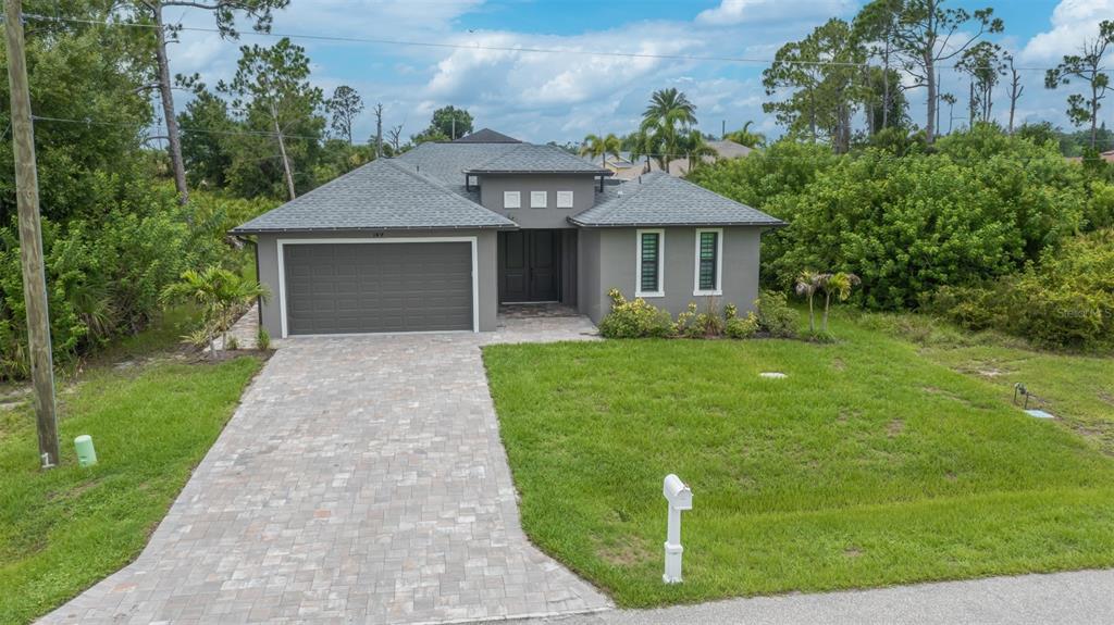 An aerial view shows a house with a screened-in pool and a paved driveway — 149 WAHOO DRIVE, ROTONDA WEST, FL