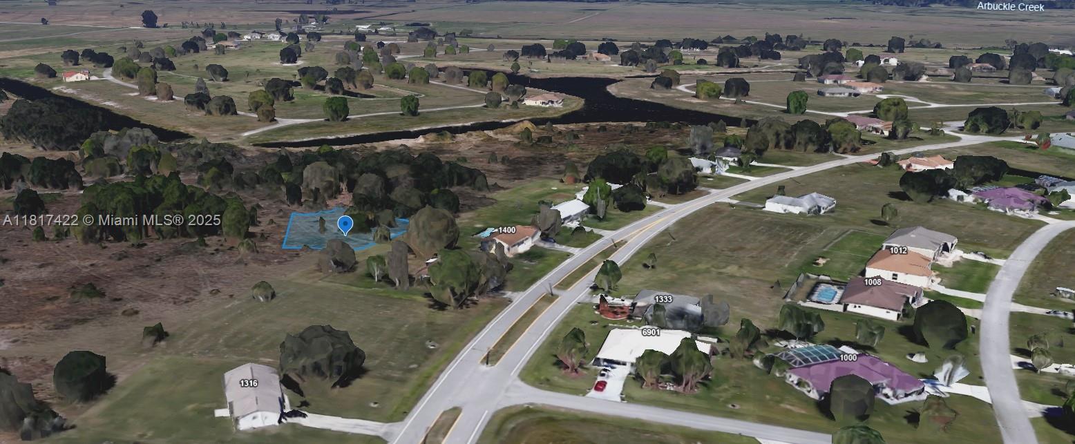 An aerial view shows a vacant lot highlighted in blue within a residential neighborhood — 1001 Little CT, Sebring FL 33876, SEBRING, FL