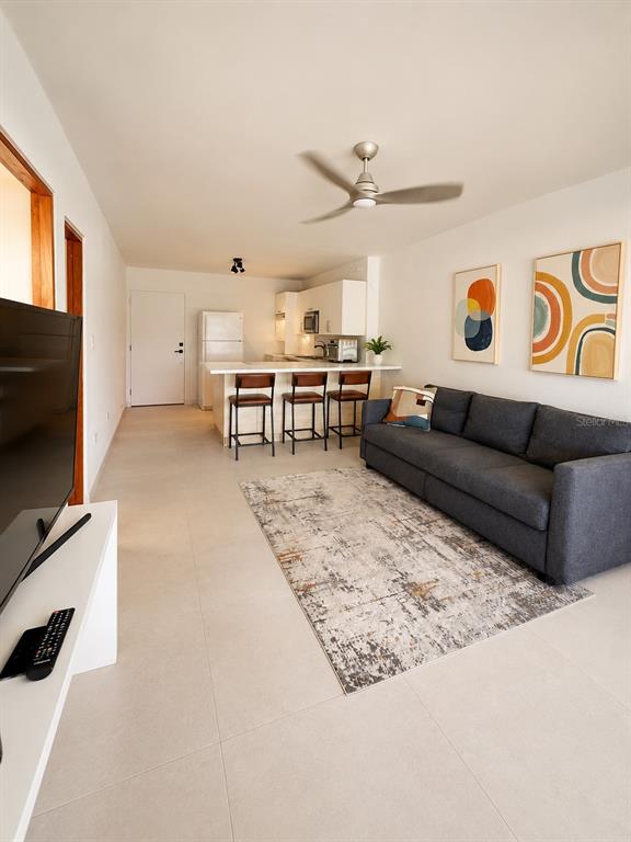 A modern open-concept living room and kitchen featuring a gray sofa and breakfast bar — 0 C. HORIZONTE, CAROLINA, PR