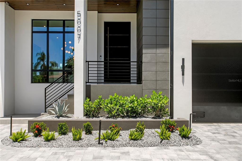 A modern two-story house with a paved driveway, two garages, and a palm tree — 5007 W SAN MIGUEL STREET, TAMPA, FL