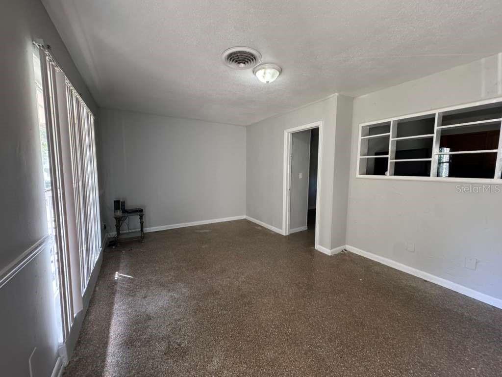 An empty room with gray walls, brown carpeting, a ceiling light, and a built-in shelf — 5717 FERNHILL DRIVE, ORLANDO, FL
